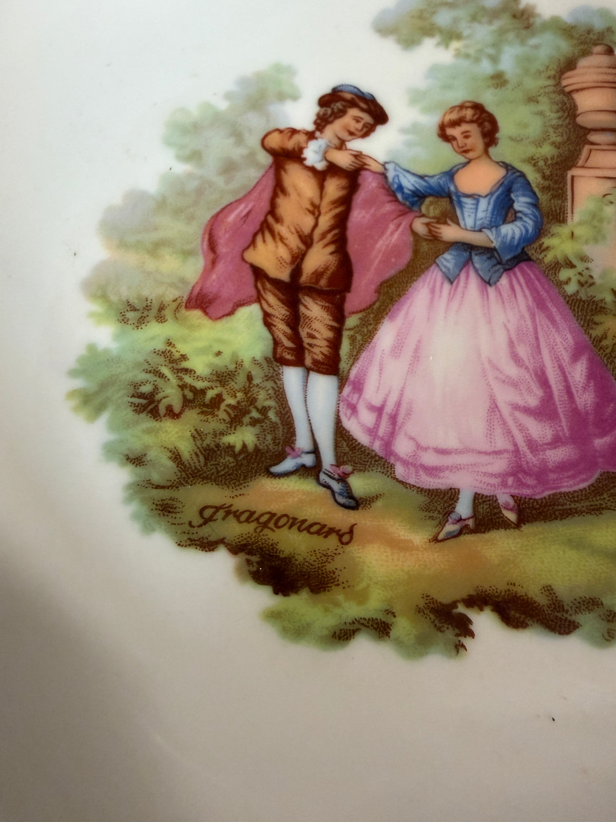 Décor Fragonard scène galante, couple dans un jardin, gros plan sur l'assiette